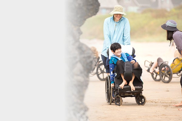 People helping and interacting with a child in a wheelchair